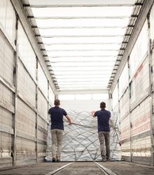 Workers pushing freight in air freight container